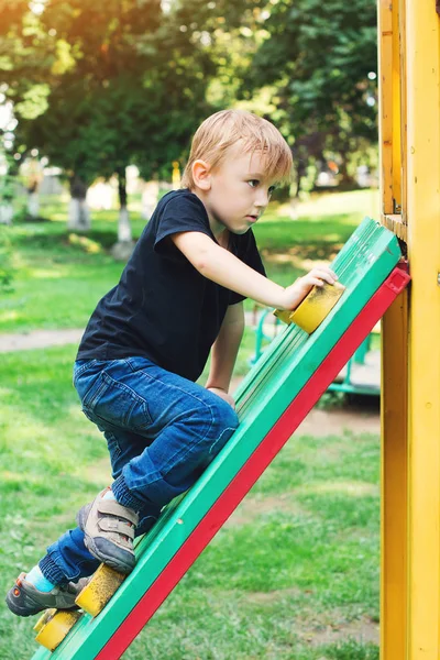 Bonito menino loiro no playground ao ar livre . — Fotografia de Stock
