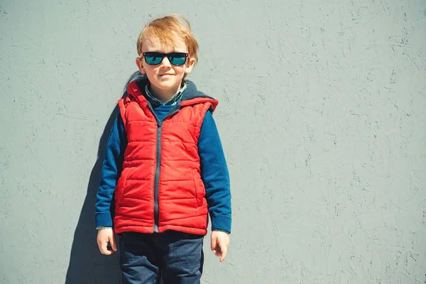 Niedlicher blonder Junge in moderner Oberbekleidung, im Freien. — Stockfoto