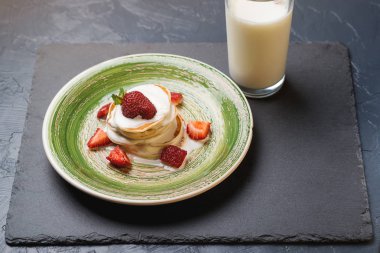 Olgun çilek ve jogurt tarafından dökme ile krep yığını.