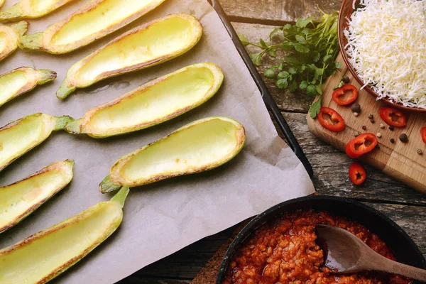 Zubereitung zum Backen von Zucchini gefüllt mit Hackfleisch, Tomaten und Käse im Ofen. — Stockfoto