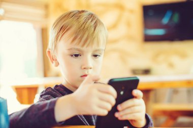 Sevimli küçük çocuk evde smartphone oyun.