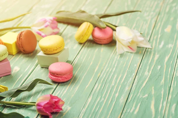 Belles tulipes avec des macarons colorés sur fond de bois verdoyant. Espace de copie. Concentration sélective . — Photo