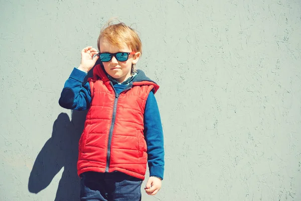 Menino loiro bonito em um outerwear moderno, ao ar livre . — Fotografia de Stock