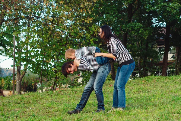 Glückliche junge Familie verbringt Zeit miteinander im Park — Stockfoto