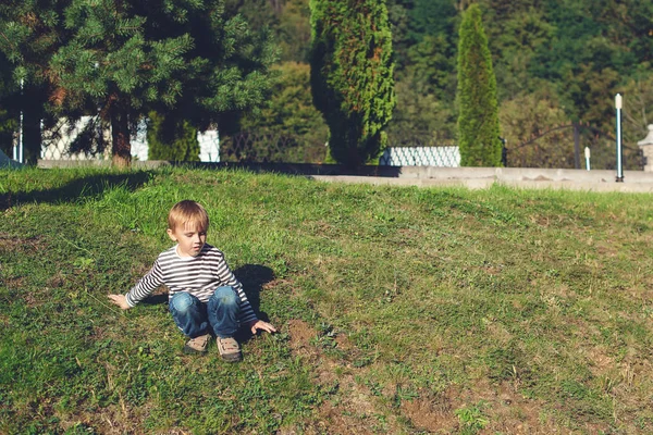 Küçük çocuk parkı yere oturmuş — Stok fotoğraf