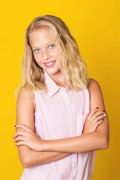 Stilig ung flicka poserar på gul bakgrund. — Stockfoto