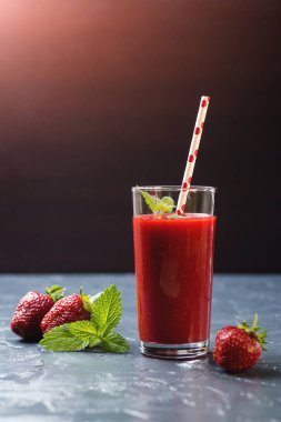 Siyah arka plan üzerine bir bardak taze çilek güler yüzlü.