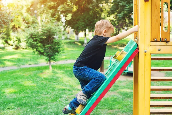 Netter blonder Junge auf Spielplatz im Freien. — Stockfoto