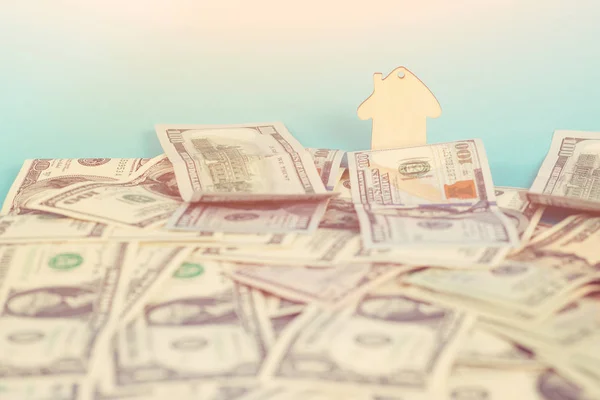 Het concept van financiële besparingen om een huis te kopen. Mini model huis achter geld achtergrond. Toned. — Stockfoto