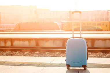 Traveler suitcase at platform outdoors in early morning