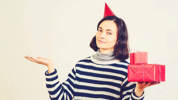 Счастливая женщина держит рождественские подарки поверх белых. Женщина с пустой ладонью для рекламы вашего продукта . — стоковое фото