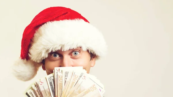 Emotional handsome guy holding money on a white background. Christmas, business and sales concept — Stock Photo, Image