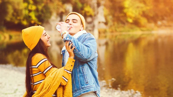 Feliz pareja joven divirtiéndose juntos en la naturaleza en otoño. Moda y belleza otoñales. Estilo de vida saludable, amor y humor . —  Fotos de Stock