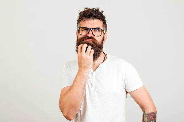 Hombre barbudo dudando de una nueva idea sobre fondo blanco. Tipo hipster barbudo pensando en un nuevo plan de puesta en marcha . — Foto de Stock