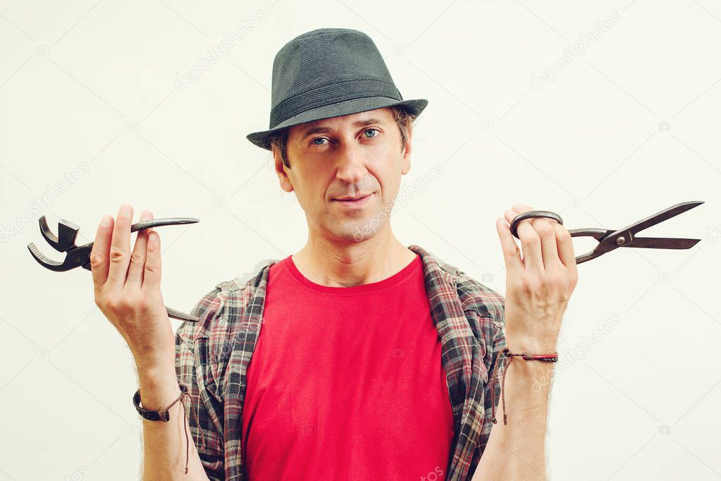 Man holds tools for repair shoes over white background. Small business and entrepreneur concept.