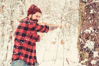 Lumberjack chopping wood in winter forest