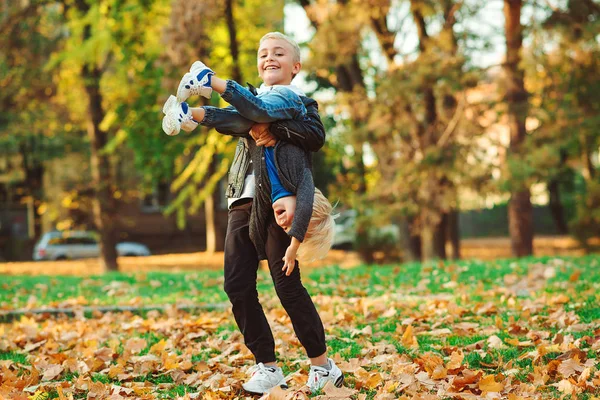 Irmãos bonitos se divertindo juntos ao ar livre. Moda de crianças, estação de outono. Família feliz em um passeio no parque de outono . — Fotografia de Stock