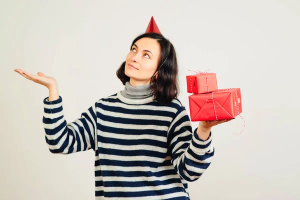 Улыбающаяся женщина держит красные подарочные коробки. Новый год, Рождество и День Святого Валентина. С днем рождения! . — стоковое фото