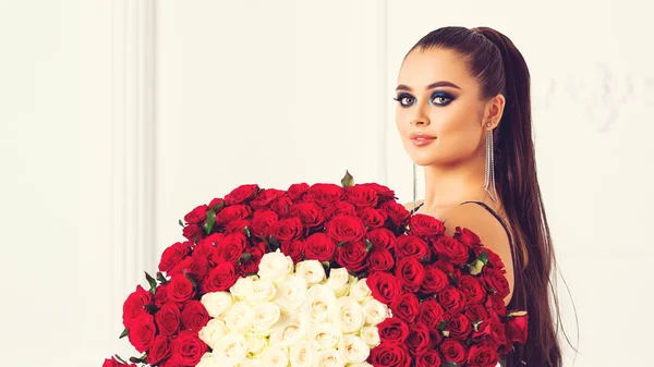 Μόδα κορίτσι με φωτεινό μακιγιάζ κρατά μπουκέτο από εκατό τριαντάφυλλα από το φίλο. — Φωτογραφία Αρχείου