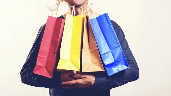 Hombre con bolsas de embalaje. Ventas estacionales. Concepto Viernes Negro. El tipo tiene muchas bolsas de compras. Gr. — Foto de Stock