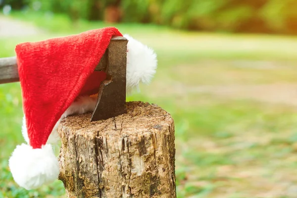 Régi balta egy fapadlóban. Karácsonyi kalap egy baltán. Jön a karácsonyi ünnep. Karácsonyi munkanap — Stock Fotó