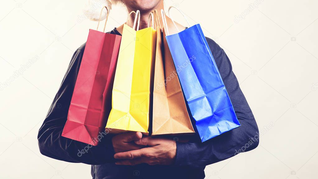 Man with packing bags. Seasonal sales. Black friday concept. Guy holds many shopping bags. Gr