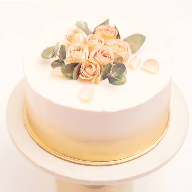 Çiçekli beyaz düğün pastası, üst manzara. Altın düğününde güllerle süslenmiş klasik pasta. Yumuşak çiçekli doğum günü pastası