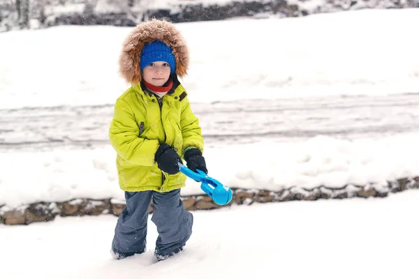 Happy gyerek hógolyókat készít a szabadban. Egy kisfiú a divatos téli ruhában sétálni. Családi téli vakáció — Stock Fotó