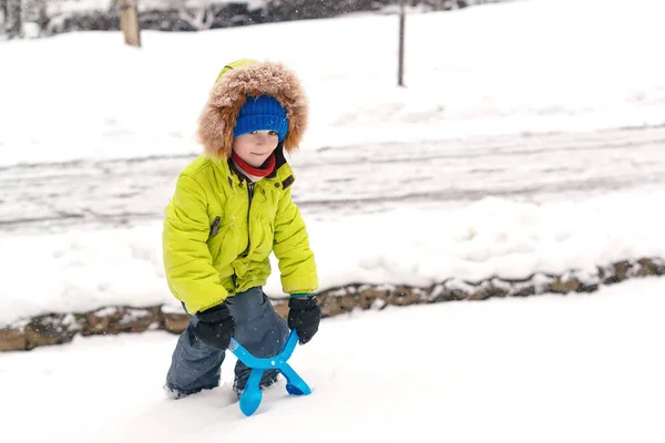Happy gyerek játszik a hóval. Egy kisfiú divatos téli szerelésben a szabadban. Családi téli vakáció — Stock Fotó