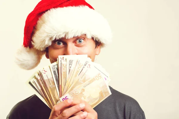 Gelukkig glimlachende man in kerstman helper hoed met geld bankbiljetten over witte achtergrond. Kerst verkoop, kortingen en financiën concept — Stockfoto