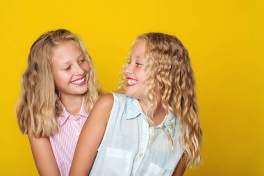 Mutlu kız kardeşler gülümsüyor ve birlikte eğleniyorlar. Güzellik ve moda