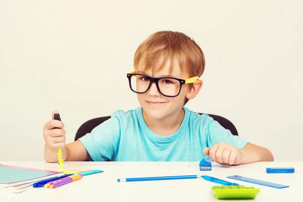 Mały uczeń studiujący i czytający książki na zajęciach. słodkie szkoła chłopiec z okulary robi praca domowa — Zdjęcie stockowe