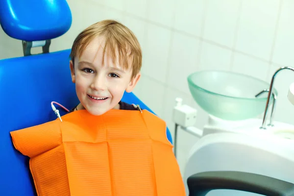 Rapazinho sorridente na cadeira do dentista, de perto. Criança durante a inspeção da cavidade oral. Conceito de saúde — Fotografia de Stock