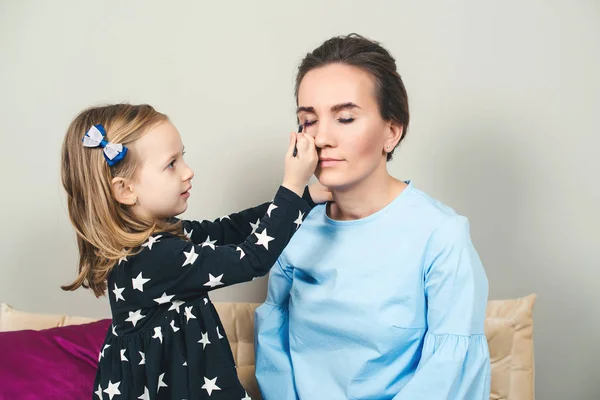 Roztomilé holčička a její máma dělá navzájem make-up — Stock fotografie