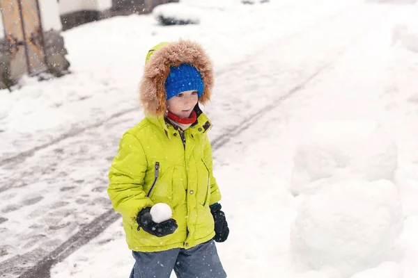 A gyerek hóban játszik a téli szünetben. Aranyos kisfiú meleg ruhában a szabadban télen. — Stock Fotó