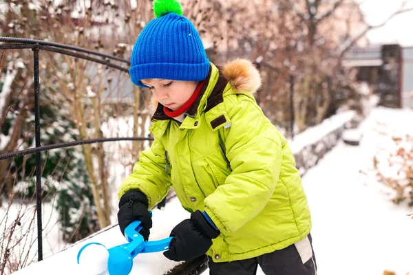 Çocuk dışarıda karla oynuyor. Kış tatili Arka bahçede kartopu yapan oyuncu küçük çocuk. Mutlu çocukluk — Stok fotoğraf