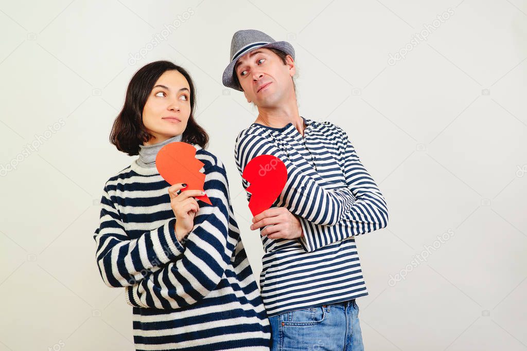 Unhappy valentine day. Young couple holding broken heart. Family quarrels and conflicts