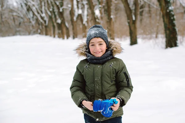 Glad leende pojke i vinterkläder under promenaden. Glad vintersemester — Stockfoto