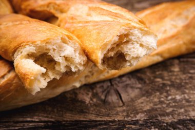 Tahta arka planda Fransız ekmeği baget ekmeği, yakın plan. Sağlıklı organik ekmek.