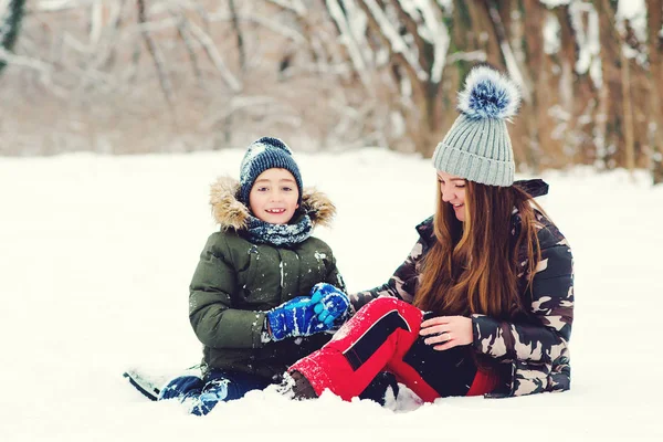 Happy family. Mother and son having fun in winter park. Family playing with snow outdoors. Happy christmas vacation. Winter fashion, lifestyle — Stok fotoğraf