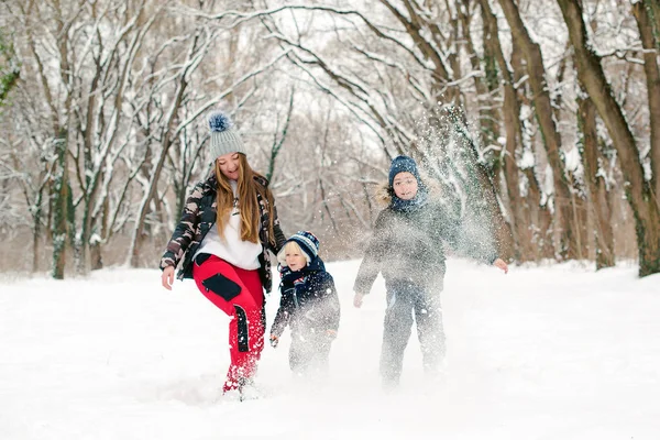 Winter family vacation. Lovely family throwing snow and having fun together. Outdoor winter activities — Stock Photo, Image