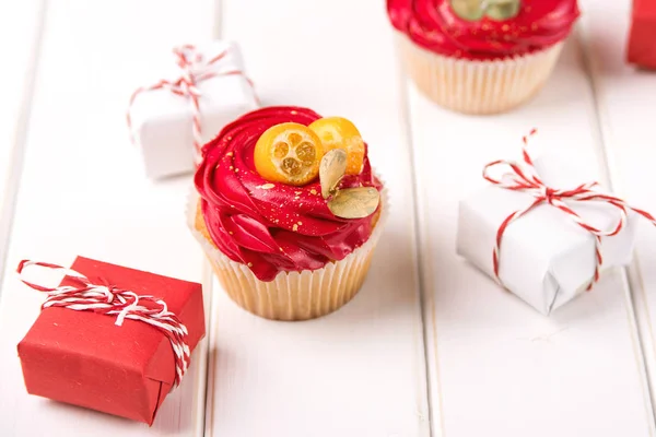 Sabrosas decoraciones de magdalenas y navidades sobre fondo blanco. Tarjeta navideña con cupcake — Foto de Stock