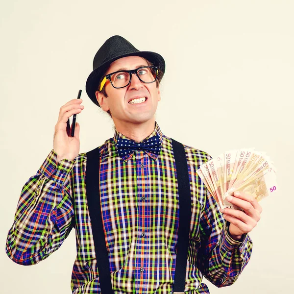 Nerd broker trzyma pieniądze i rozmawia przez telefon. Prognozowanie stóp finansowych. Złe wiadomości finansowe — Zdjęcie stockowe