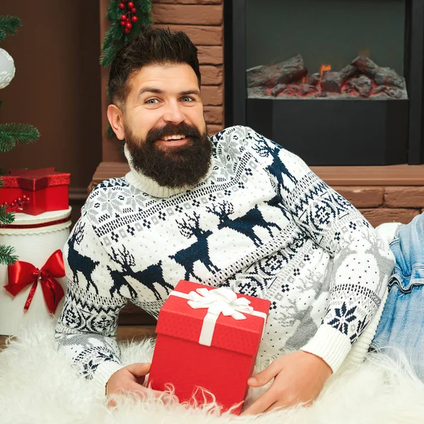 Noel kutlaması ve hediyeler. - Mutlu yıllar. Evde şöminenin yanında sakallı yakışıklı bir adam var. — Stok fotoğraf