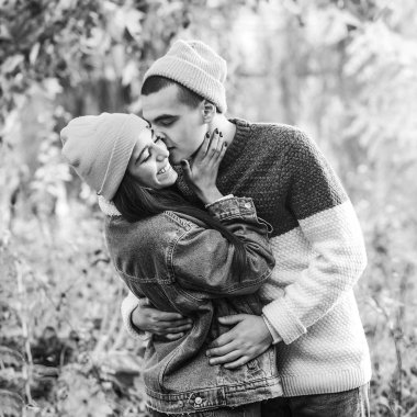 Yakışıklı adam kız arkadaşına sarılıp öpüyor. Sevgililer Günü. Güzel bir çiftin doğada randevusu var. Birbirine aşık çift