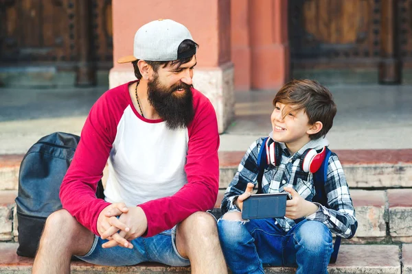 Pai e filho felizes conversando ao ar livre. Férias em família, viagens e fim de semana — Fotografia de Stock