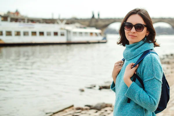 Girl traveler enjoying great view on Prague city. Stylish woman with backpack travel in europe