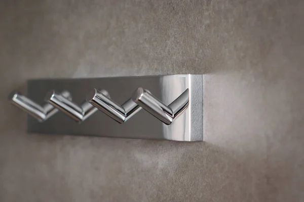 Crochets métalliques montés sur mur gris moderne dans une salle de bain, gros plan — Photo