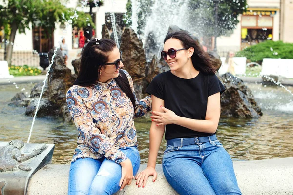 Felices novias hablando y riendo al aire libre. Dos jóvenes viajan juntas. Vacaciones de verano, viajes y estilo de vida —  Fotos de Stock