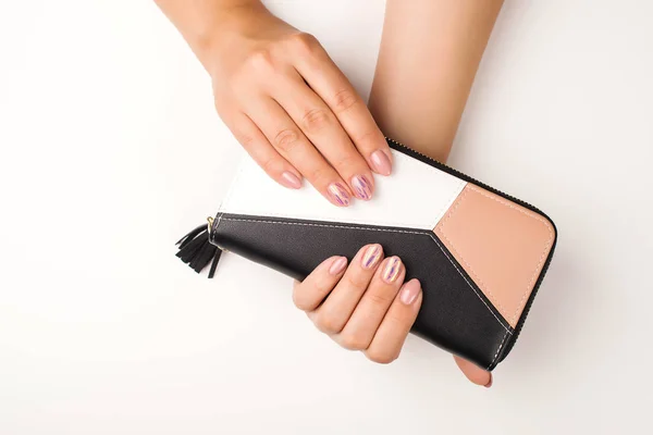 Female manicure hands. Fashion young woman hands holds purse. Women hands, top view. — Stockfoto